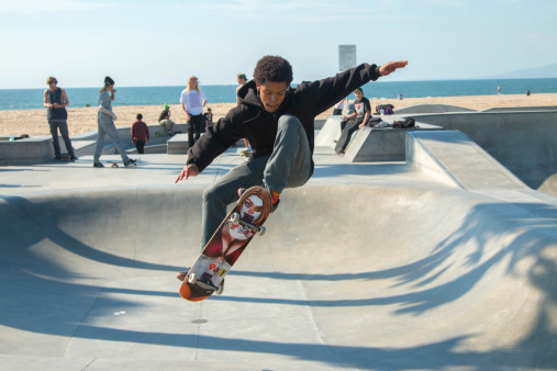 Los Angeles, California -February 4, 2014: At the iconic skate park in Venice Beach, California, a local skateboarder practices his skills.