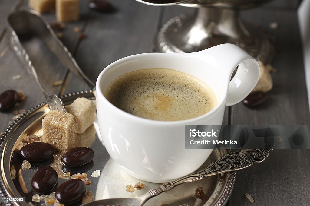 Cup of espresso, sugar cubes and chocolate candy Cup of espresso, sugar cubes and chocolate candy on rustic wooden background Mug Stock Photo
