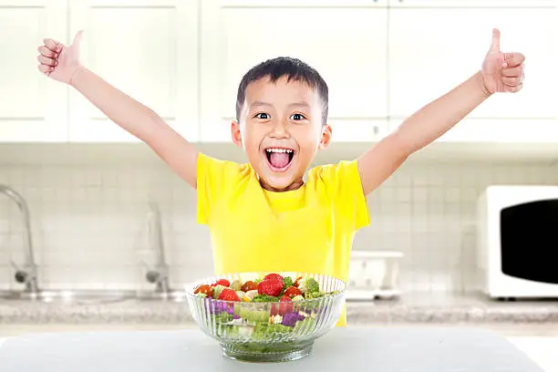 Photo of Pleased child with salad