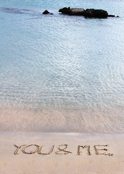 istock You and Me message written in sand on a beach 476283495