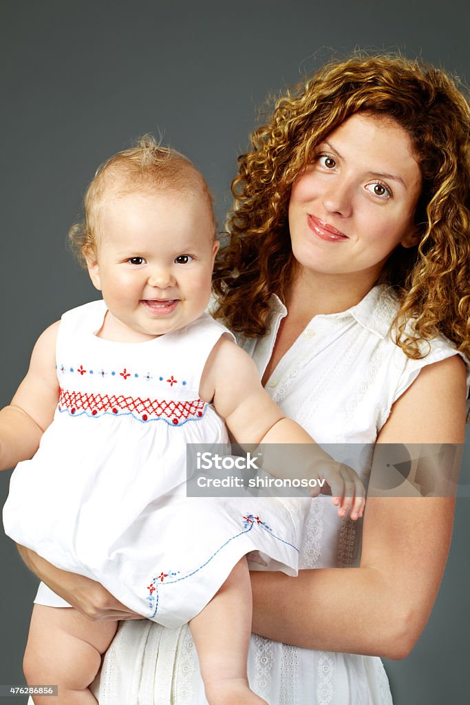 Mother and daughter Portrait of happy woman holding her cheerful daughter 12-17 Months Stock Photo