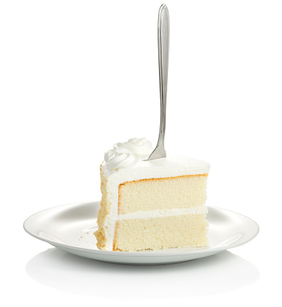 Slice of layered vanilla cake with white icing. 