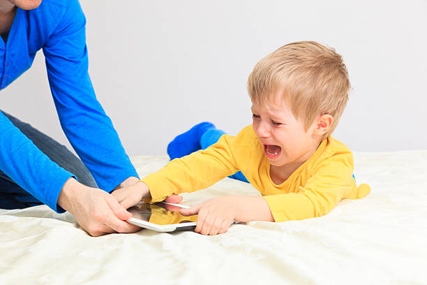 computer addiction computer addiction, parent taking out touch pad from child dragging photos stock pictures, royalty-free photos & images