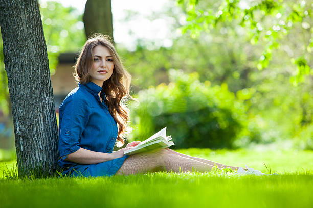 istock Girl reading a book in park 476290360