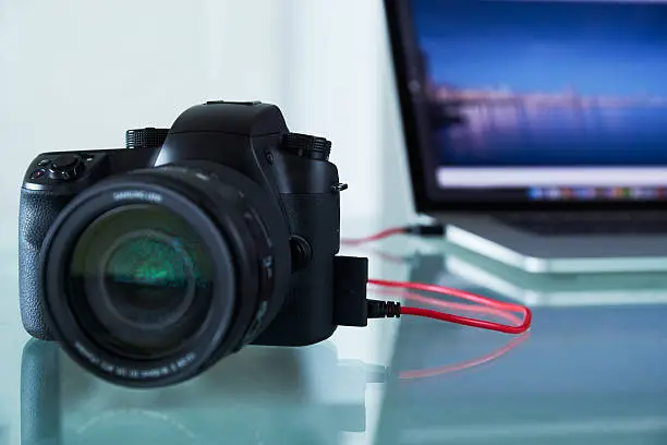 Photo of DSLR Photo Camera Tethered To Laptop Computer With USB Cable