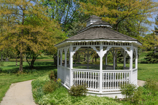 Gazebo in sunny Spring park with lots of new leaves and greenery, Michigan, USA.