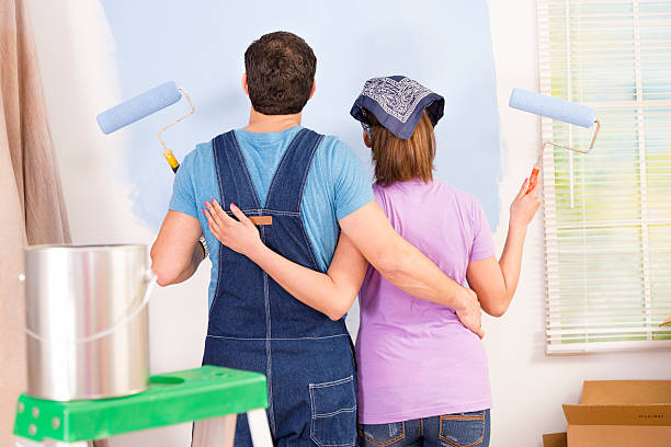 istock Construction: Latin couple. Home improvement projects. Painting a wall. 476296975