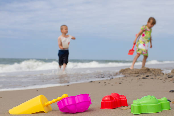 A boy and a girl having fun with water and sand at beach. Picture taken during hot summer time.