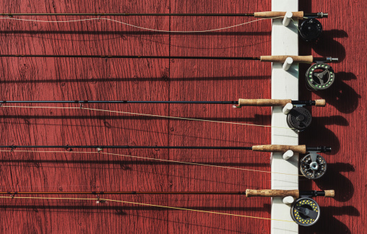 Fly rods hang on the rack of a salmon fishing lodge.