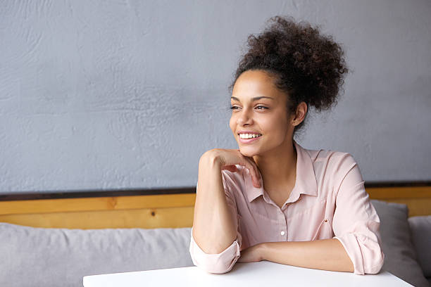 istock Attractive young woman sitting indoors smiling 476314034