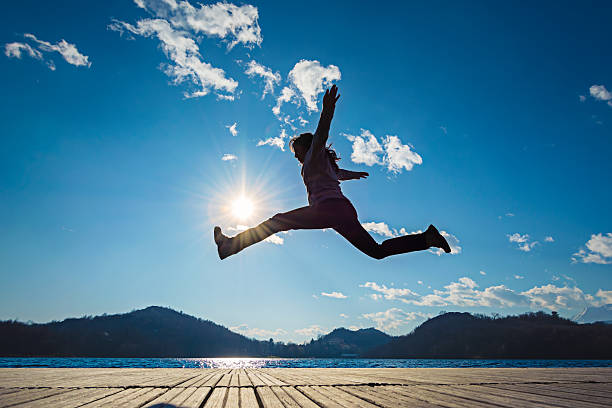 Girl jumping in the sun stock photo
