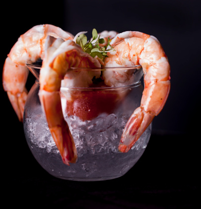 Big Juicy Raw Shrimp with lemon, cocktail sauce on ice in dish