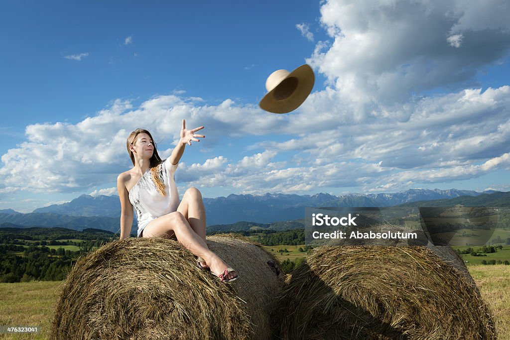 Jeune femme sur un «Bale hacheuse lancer Chapeau de paille - Photo de Chapeau de paille libre de droits