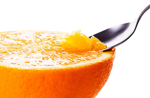 istock Orange close up.Eating with spoon. Macro.isolated on white. 476324552
