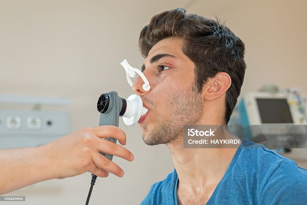 Doctor reviews patient's lung capacity with a peak flow meter Medical Test Stock Photo