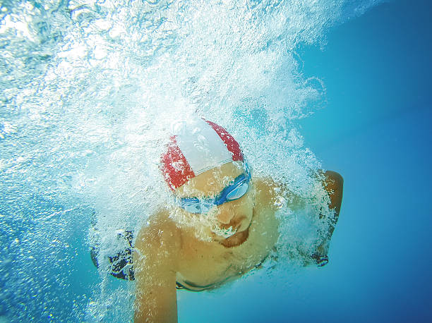 istock Man jumping and diving in swimming pool 476327314