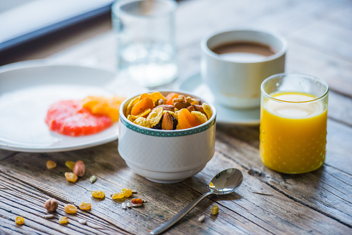 Healthy breakfast on wooden table - cereals, fresh orange juice, citrus and coffee