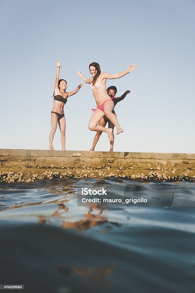 Trois femme sauter dans la mer au cours de l'été - Photo de 18-19 ans libre de droits