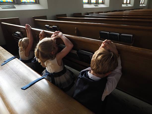istock Children Kneeling and Praying In Church 476330392