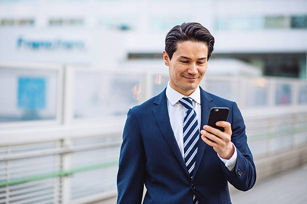 東京で日本のビジネスマン、スマートフォン、屋外でのリラクゼーション - japanese culture japan japanese ethnicity asian and indian ethnicities ストックフォトと画像