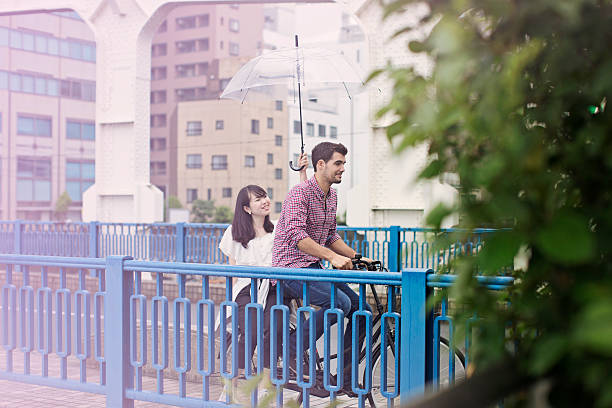 Couple Riding Bicycle on Rainy Day in Tokyo.