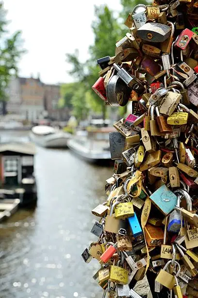 Padlocks attached to a bridge over a canal in Amsterdam, the Netherlands.