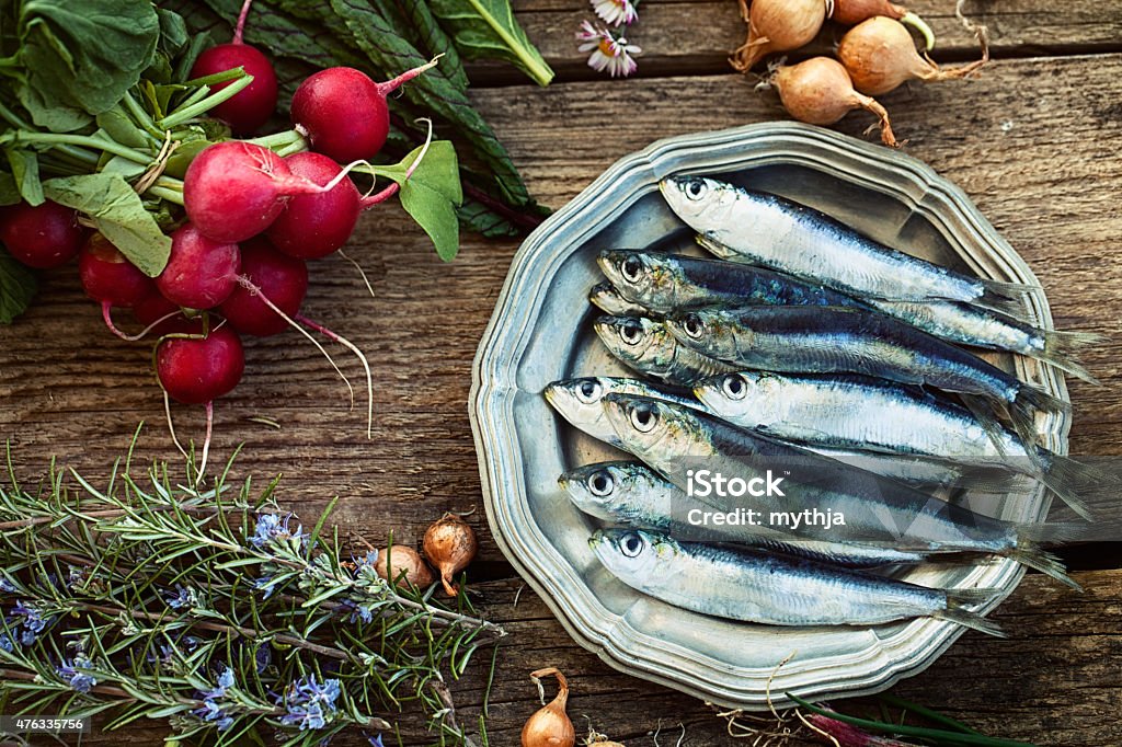 Fresh sardines Fresh sardines. Fish with vegetables. Mediterranean fish on plate Sardine Stock Photo