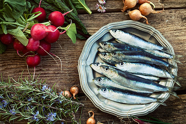 Fresh sardines Fresh sardines. Fish with vegetables. Mediterranean fish on plate sardine photos stock pictures, royalty-free photos & images