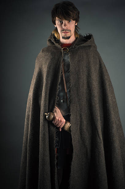 wandering man in woolen cape with a sword isolated on gray background