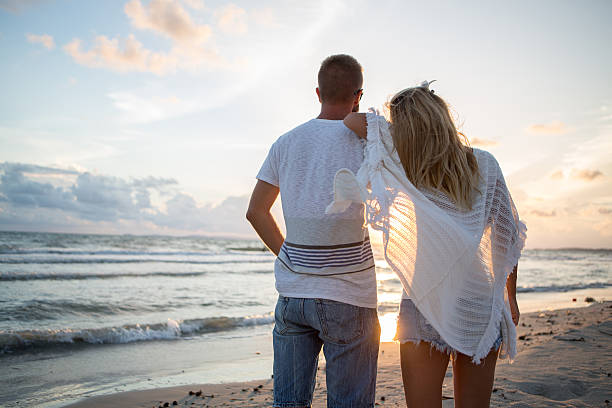 istock Young couple on the beach watching the sunset 476342138