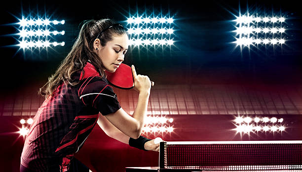 Young pretty sporty girl playing table tennis on black background stock photo