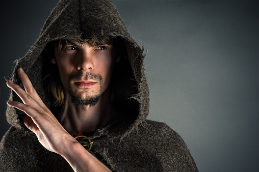 Portrait handsome man in a cape isolated on gray background