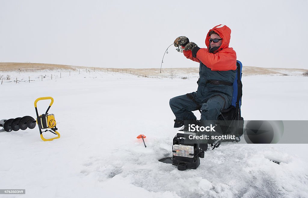 Ice fishing Ice fisherman reeling in a fish Ice Fishing Stock Photo