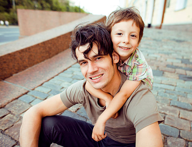 istock little son with father in city 476351629