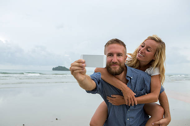 istock Young couple taking fun selfie on the beach 476351646