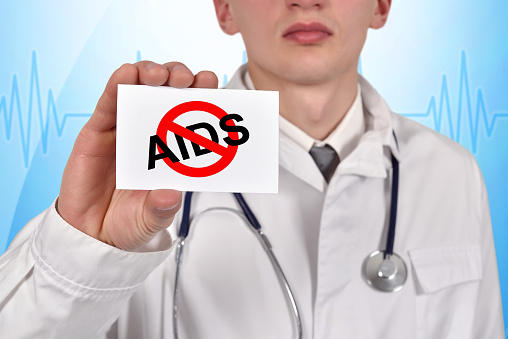 doctor holding visiting card with stop aids symbol