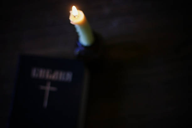 istock burning candle and bible religion 476351818