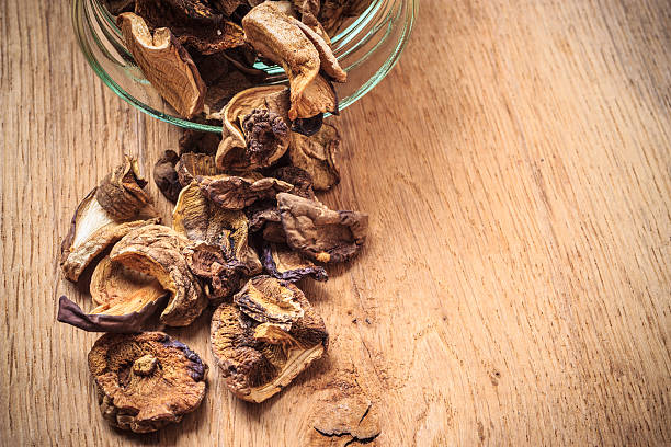 istock Dry mushrooms in jar on wooden table. 476352186