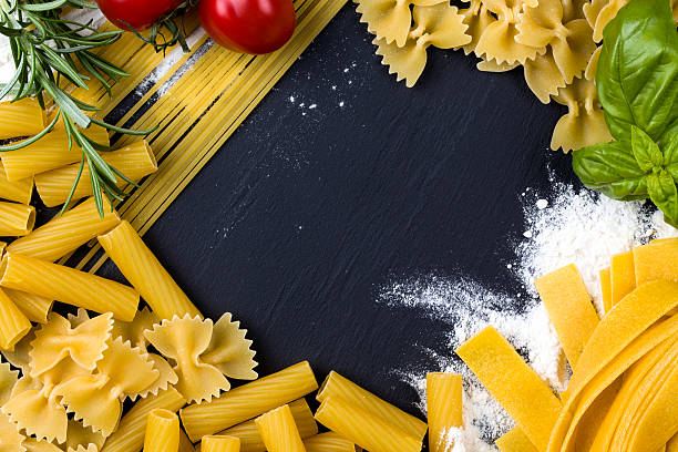 dried pasta on black stone background , pasta concept stock photo