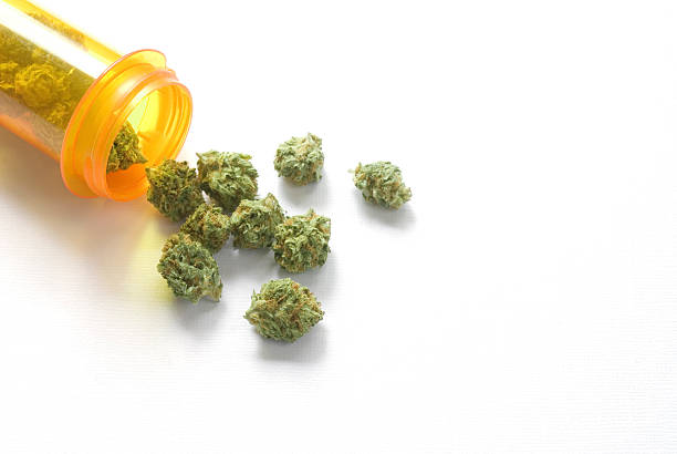 medical marijuana with prescription bottle Marijuana buds scattered by a prescription pill bottle medical cannabis stock pictures, royalty-free photos & images