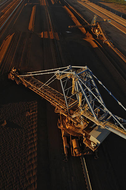 Iron ore reclaimer and iron ore stockpile A reclaimer in a stockyard used to move stockpiles of crushed iron ore on a mine site. Reclaimer stock pictures, royalty-free photos & images