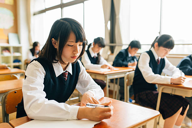 Japanese High School Students doing exams Japanese Junior High School Students filling an exam. japanese boy and girl stock pictures, royalty-free photos & images