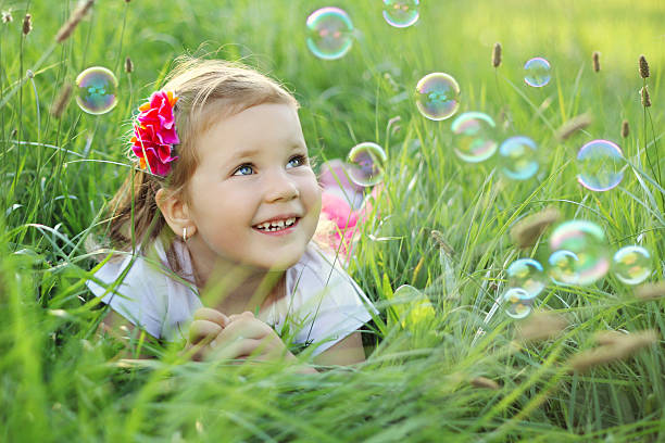 istock Happy little girl playing with bubbles 476368763
