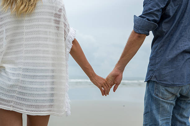 istock Young couple on beach holding hands 476371104