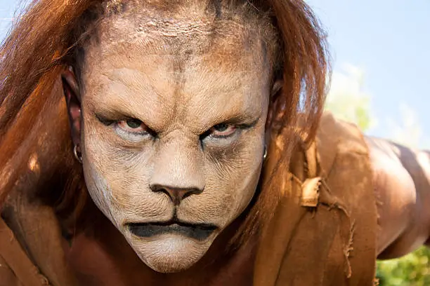 Close -up and meancing face of a Lion man looking into the camera.  Fantastic special FX make up by Rayce Bird.