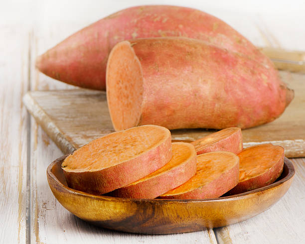 istock Raw sweet potatoes on a wooden table . 476375508