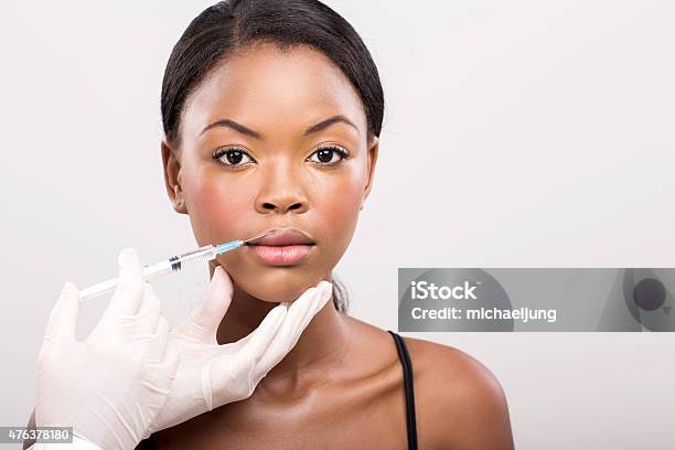 African Girl Receiving Cosmetic Injection On Her Lips Stock Photo - Download Image Now