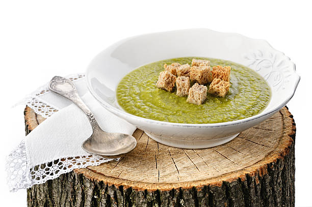 Green pea cream soup with toasts stock photo