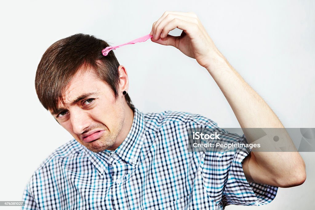 I'm gonna need some scissors.... Portrait of an unhappy man with bubblegum in his hair Bubble Gum Stock Photo