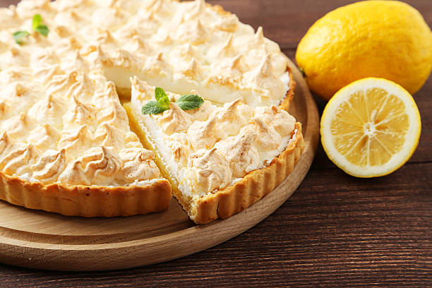 istock Lemon meringue pie on cutting board on brown wooden background 476383868